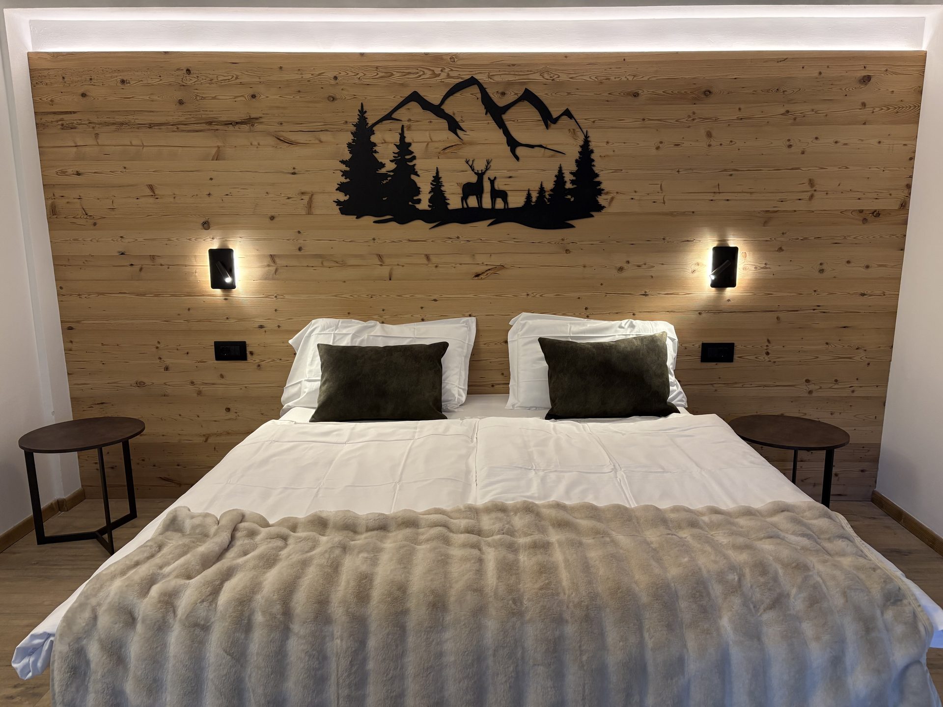 Alpine Family dell'Hotel Kapriol: letto matrimoniale e testata con montagne e cervi