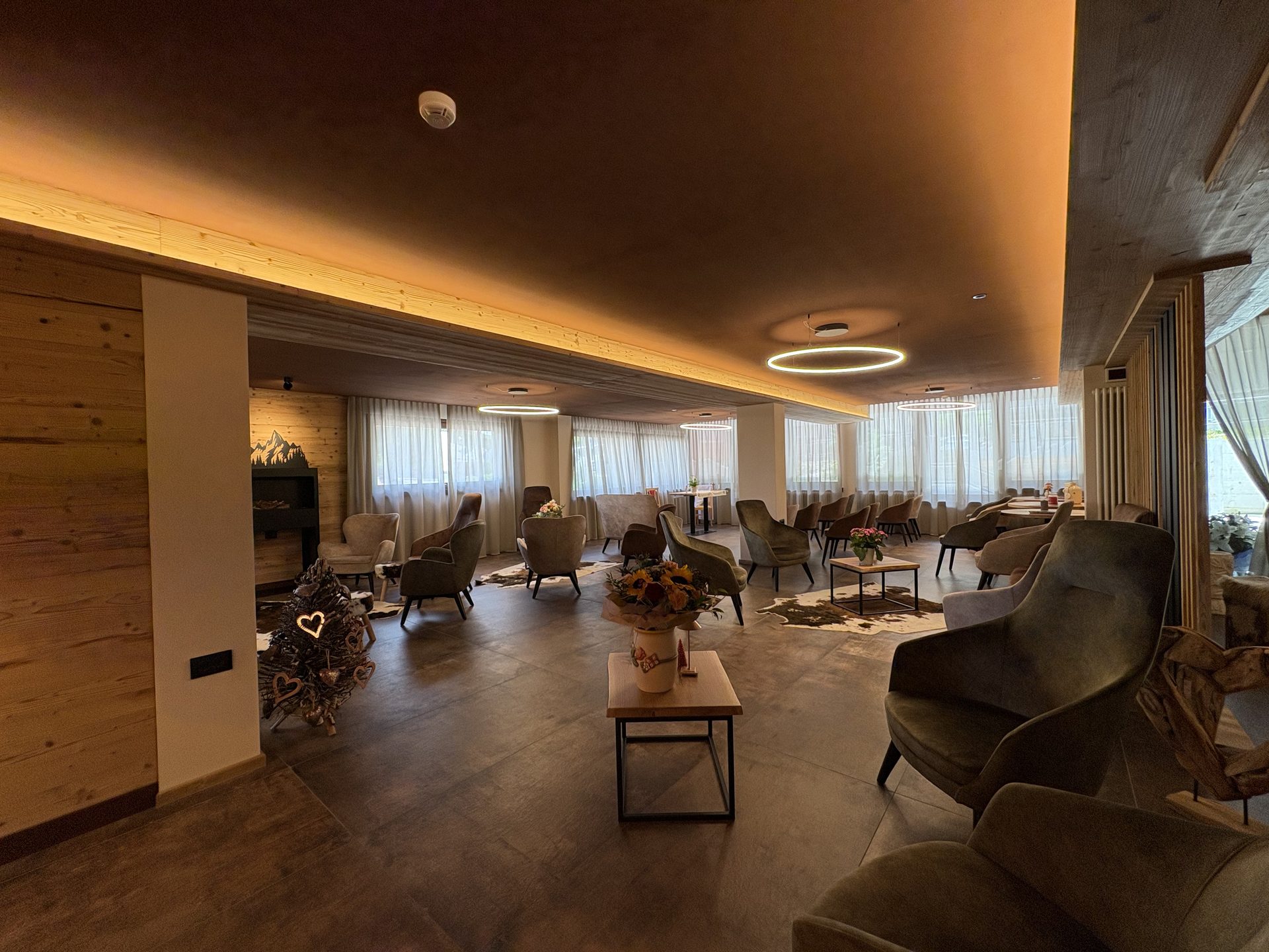 La nuova hall dell'Hotel Kapriol con poltroncine e tavolini in legno